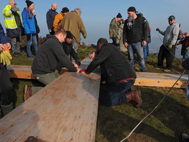Volunteers assemble the cross before it is hoisted into place