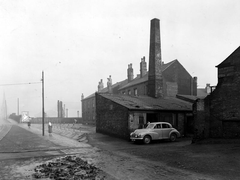 Looking north along Balm Road in December 1951, with the entrance to Robinsons scrap metal yard. A Morris Oxford car is parked in the entrance with a man nearby.