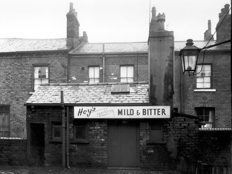 Back Addington Street in December 1958. Pictured is the outside toilet building at the rear of the New Fleece Inn, a House of Hey, beer house. The pub can be reached through the doorway on the left.