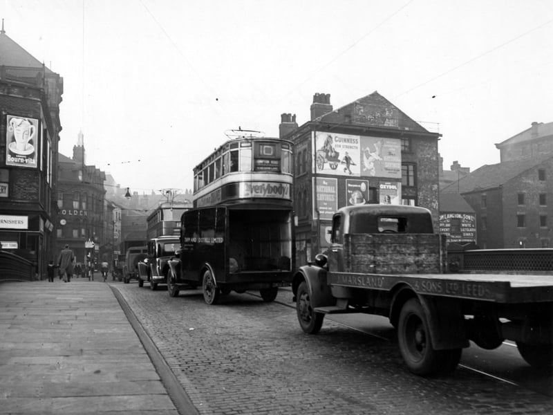 Looking north onto Briggate in November 1949. The nearest lorry and van have signs for 'J. Marsland & Sons Ltd.' and 'Tapp & Toothill Limited' on them respectively. A number 10 tram to Compton Road is visible.