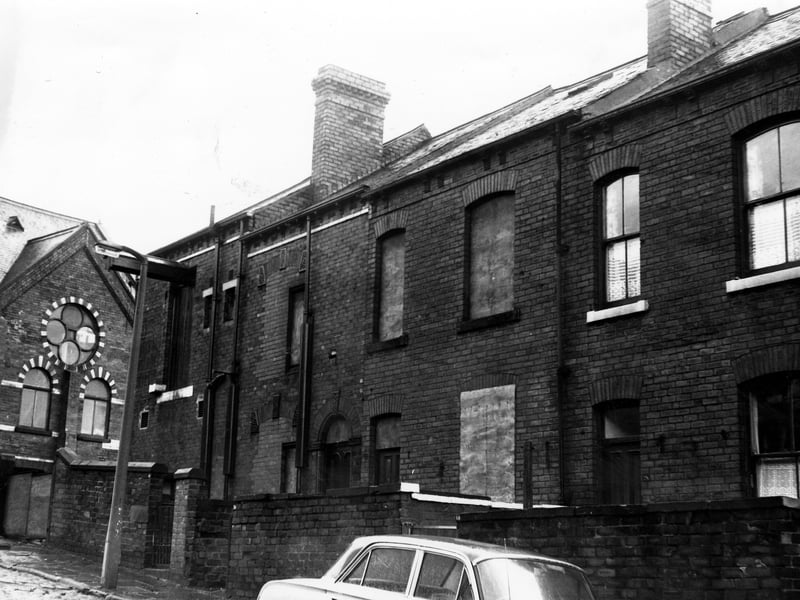 A row of terraced houses on Alexandra Crescent in December 1972. Number 32 is bricked up while number 30 has been borded up. The large building visible on the far left is the Westfield Works.
