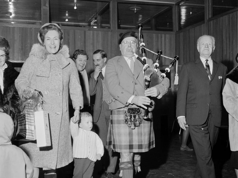 Stage actress Caroline Kaart is greeted at Turnhouse Airport by Baillie Hugh MacPherson playing his bagpipes in March 1966.