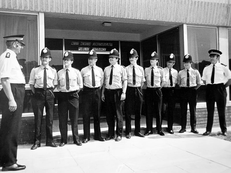 The opening of a new police headquarters in Telford in June 1976. The original caption reads: 'The new South Telford sub-divisional police headquarters at Malinslee House, Telford Town Centre, officially opened this week to replace the old premises at Dawley. At the entrance to the new building one of the first shifts prepare to leave, watched by Chief Inspector Brian Gradwell, left, officer in charge, and Inspector M Read.'