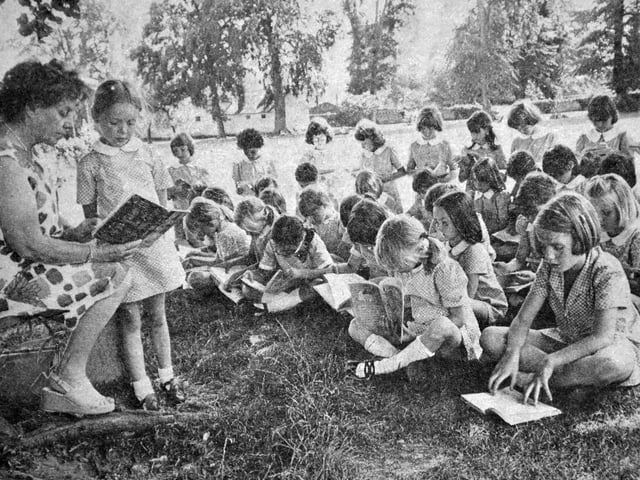 'An outdoor lesson for children of Bellan House School, Oswestry. Class teacher Miss M Jones took the youngsters into Cae Glas park for a reading lesson. Helping to lead the lesson with Miss Jones is Samantha Shaw.' Taken during the famously hot summer of '76.