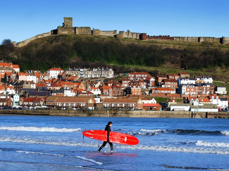 A lone surfer walks out to catch the waves in February 2003.