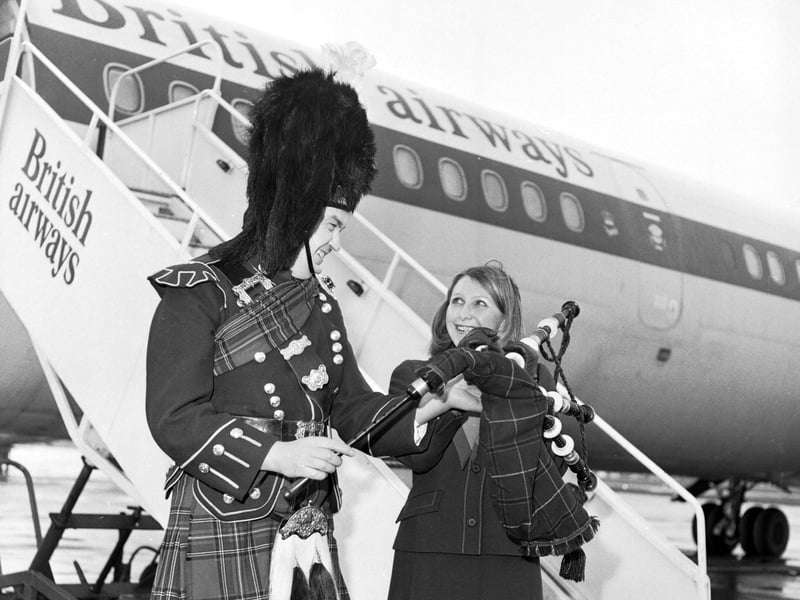British Airways steward A McKenzie and Pipe Major Smillie wait to welcome passengers on board the first Edinburgh-London shuttle flight from Edinburgh Airport in April 1976