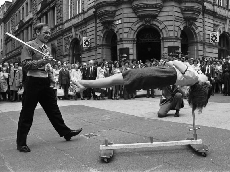 John Baird, of the Scottish Conjuring Association, and his assistant Evelyn Rose perform their sword-balancing trick for the crowds on Buchanan Street, Glasgow, in June 1976