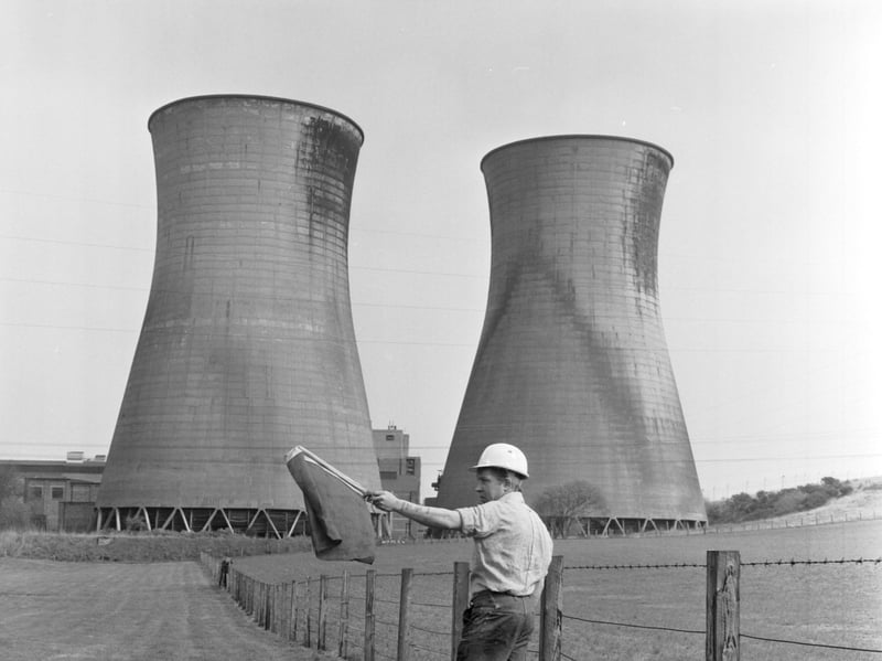 A worker with a flag clears the area before Bonnybridge Power Station is demolished in April 1976