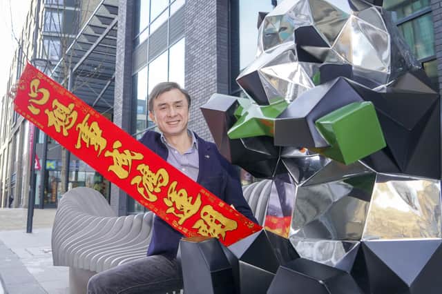 Jerry Cheung with a banner that reads Happy New Year for Chinese New Year at New Era Development in Sheffield, pictured in 2021. Picture Scott Merrylees