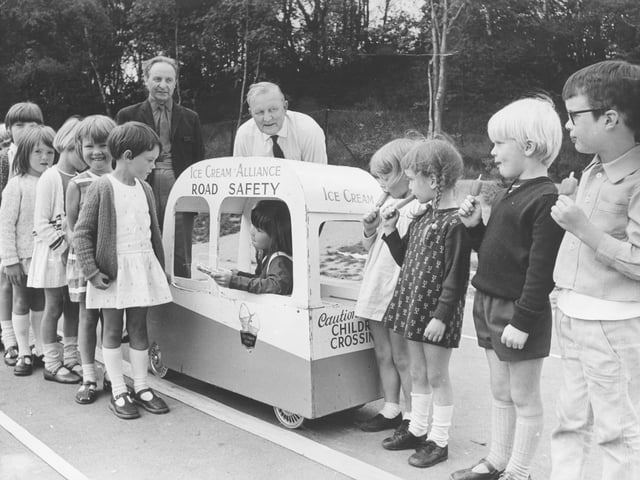 July, 1971: 'Little Susan Wood (6) serves her friends with ice lollies at Woodside Infants' School. Shropshire County Road Safety Officer Mr A E John is seen with Mr G Moruzzi (left) of Blewshill Creamery, vice-chairman of the Ice Cream Alliance road safety committee, during instruction on road safety with ice cream vans yesterday. The alliance has provided over 60 miniature ice cream vans for instructional work throughout the country.'
