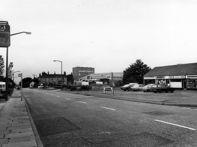 Looking north-east along Whitehall Road in August 1981. Just out of view on the left is the Malt Shovel public house; only the sign is visible. On the right is a row of shops comprising of The Apple Tree newsagent and off-licence, P.P.B. Racing Ltd., Carparts and Chinese Food takeaway. Further along are Whitehall Tyres and Plasticisers Ltd.