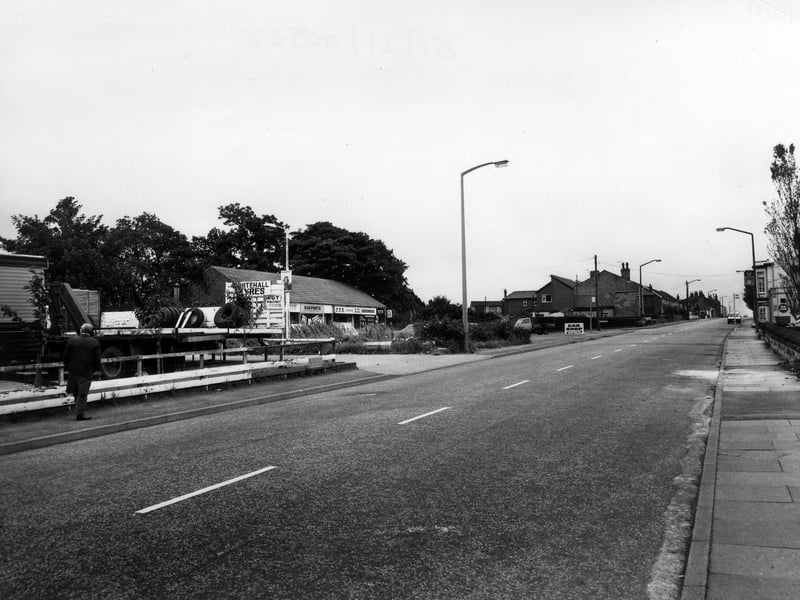 Looking south-west along Whitehall Road. Whitehall Tyres is on the left, then a row of shops which comprises of Chinese Food takeaway, Carparts, P.P.B. Racing Ltd. and The Apple Tree newsagents and off-licence. On the right is the Malt Shovel public house. Pictured in August 1981.