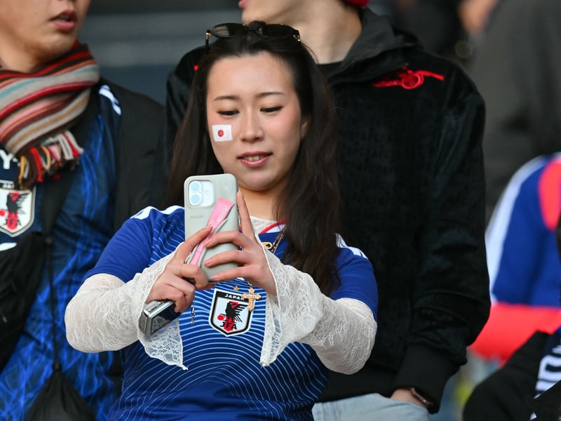 A Japan fan takes a photo ahead of kick off.