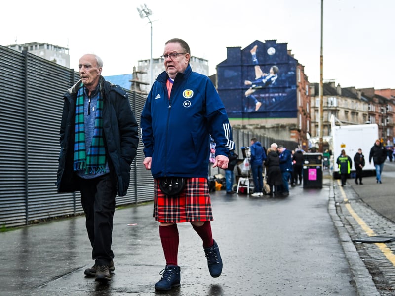 Scotland fans arrive at the stadium with the Scott McTominay mural in the background.