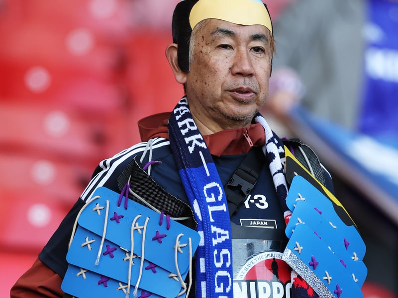 A fan of Japan shows their support in the stands while wearing fancy dress.