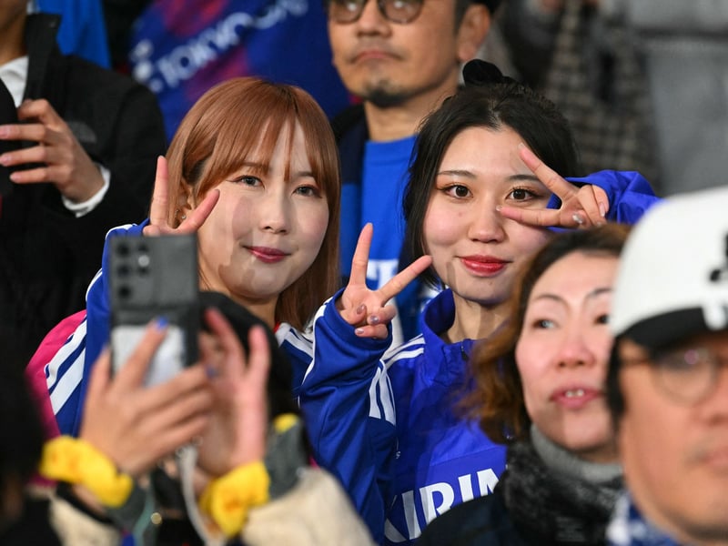 Japan fans pose for a picture in the crowd.