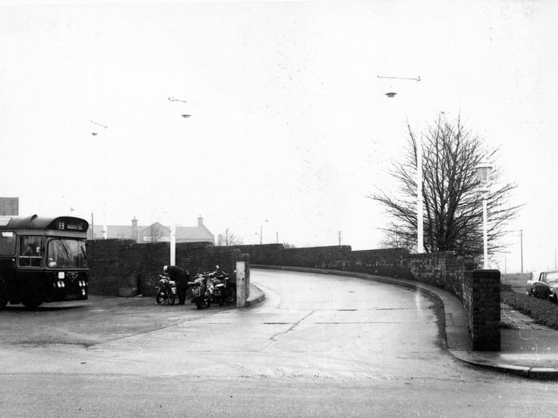 Looking north east at the entrance of the southern end of the Bramley Omnibus Garage. To the left is a number 79 bus, next to it are four parked motorcycles. One of the owners is stood by his bike. Pictured in November 1968.