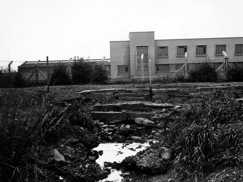 Belle Isle Beck with the National Service Government Training Centre in the background behind a barbed wire fence. The training centre was located in Parkside Lane, off Dewsbury Road, at the rear of the Crescent Cinema. The junction with Parkside Lane is next to the junction with Garnet Road. Pictured in August 1949.