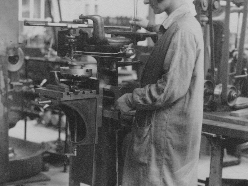 An employee of the Leeds Meter Company engaged in engraving with machinery.