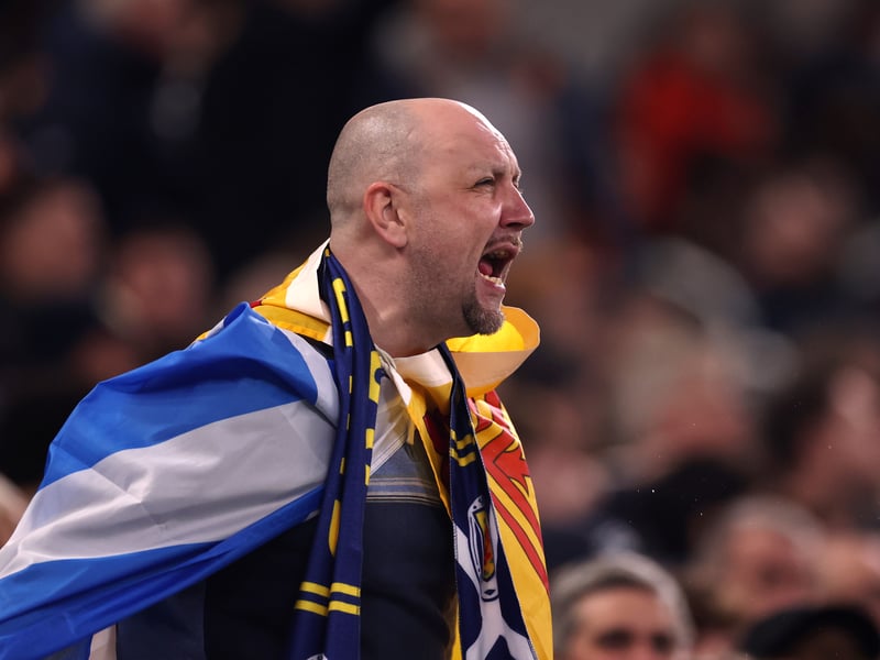 A Scotland fan sings the national anthem from the stands.