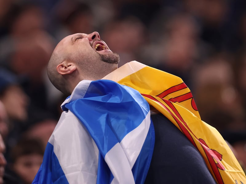 A Scotland fan shouts from the stands.
