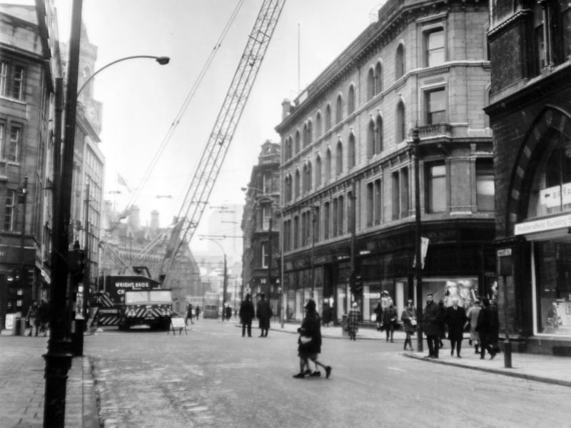 A 130-foot crane is prepared for lifting heavy equipment onto the roof of Brown, Muff and Co, on Market Street, Bradford, where two lifts are being installed, in February 1969