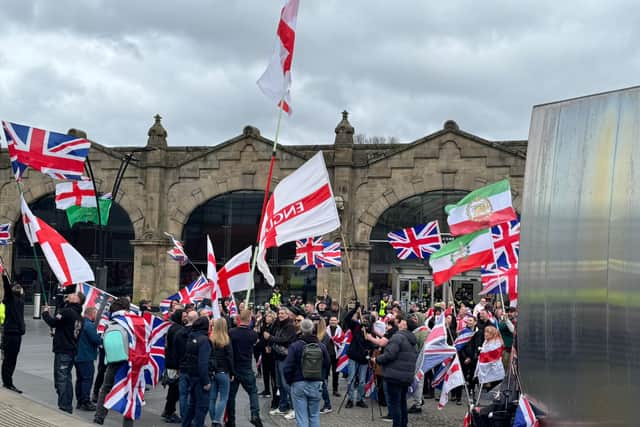 Raise the Colours protesters hold up flags outside Sheffield railway station