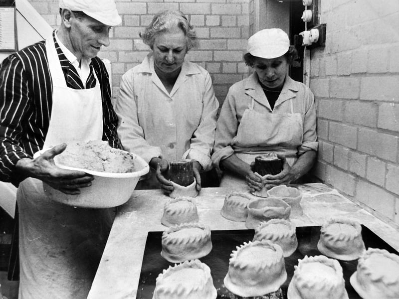 Richard Jones and Sons butchers in Leg Street, Oswestry, where traditional hand-raised pork pies were being prepared. The business, owned by Mrs Anne Jones, gained international attention after the editor of a worldwide food magazine visited and featured their high-quality produce. Mrs Jones attributed the pies’ success to traditional recipes with “special” secret additions. Pictured at work hand-raising the pies are Frank Holgate, Mrs Jones, and Mrs May Hardman, on October 7, 1969.