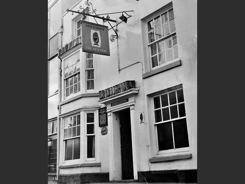 The Dun Cow public house as it appeared on January 22, 1969. The sign identifies it as an Ind Coope establishment, with the name of the licensee, Norman William Mansell, displayed above the entrance.