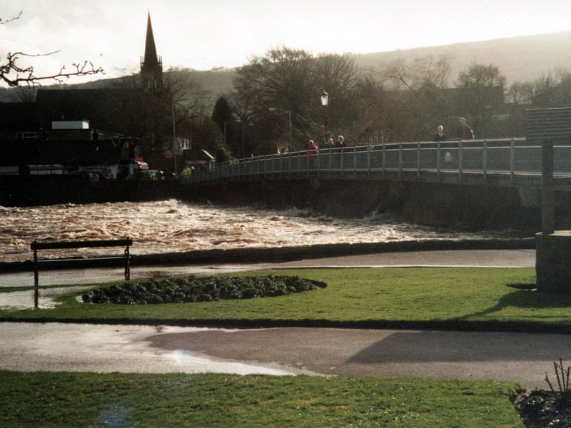 River Wharfe and Bridge Street bridge in April 2002. In foreground is a paving and grassed area showing evidence of flooding, visible on the right is a well. The church in the distance is Bridge Street United Reform Church.