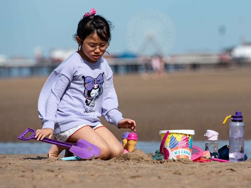 A young child builds sandcastles on Blackpool beach in the sun. Photo: Lucinda Herbert