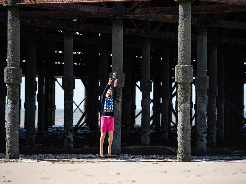 A youngster throws sand in the air under South Pier. Photo: Lucinda Herbert