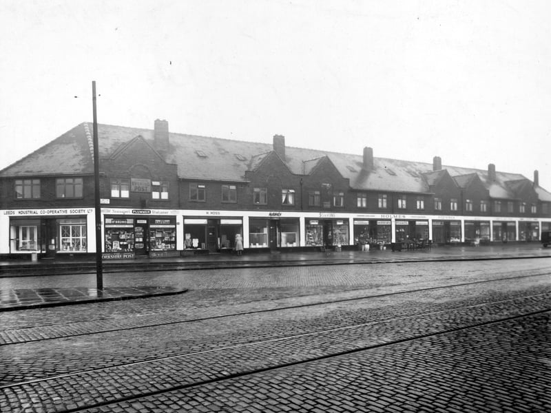 Shops at nos. 21-43 Compton Road. Leeds Industrial Co-operative Society Ltd. dairy, Plummer's newsagent, M. Moss draper, Audrey Marshall ladies hairdresser, Sorkin Stores grocers, W. Holmes furniture dealer, Fitzpatrick's florist, Gill's butchers, Thomas Bird boot dealer, Pearlson chemist and Thomas Ramsden dentist shown. Pictured in December 1948.