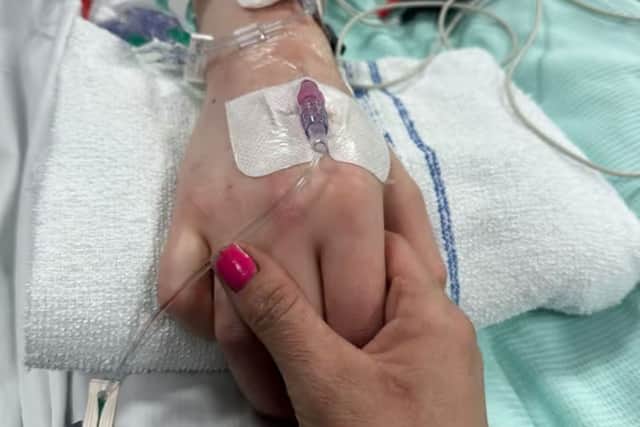 Rebecca Carnell pictured holding her son Logan's hand whilst he was in intensive care after the crash