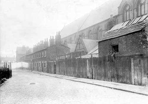Rider Street in March 1922. It was located off Burmantofts Street and shows wooden sheds to the right. St. Patricks Roman Catholic Church can be seen behind the houses.