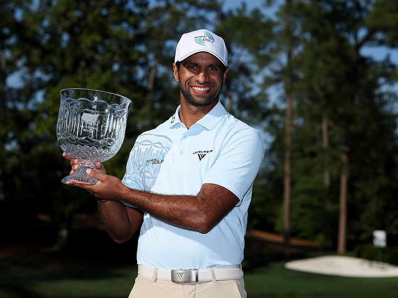 Aaron Rai of England poses with the trophy after winning the Par Three Contest.