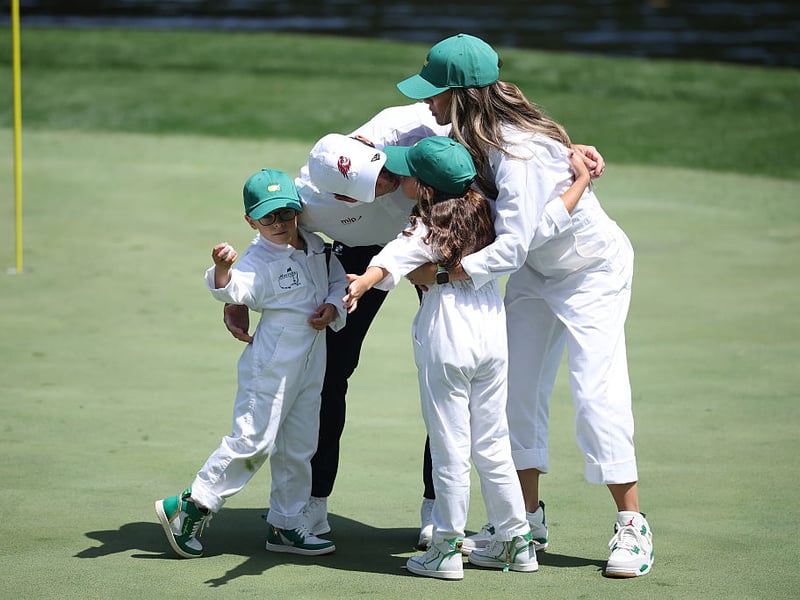 Sergio Garcia of Spain embraces his family, son Enzo, daughter Azalea and wife Angela Akins Garcia on the ninth green.