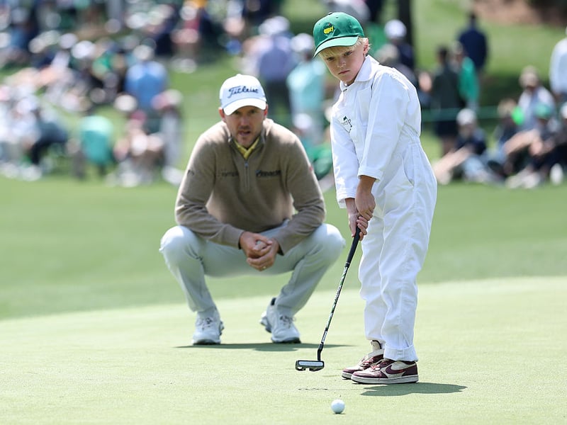 Russell Henley of the United States watches his son Robert putt on the second green.