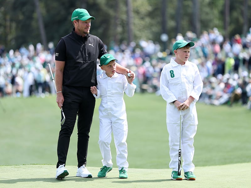 Danny Willett of England and his sons look on while playing the second hole.