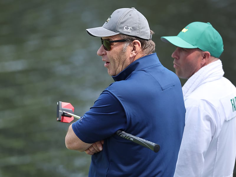 Sir Nick Faldo and his caddie look on during the Par Three Contest.