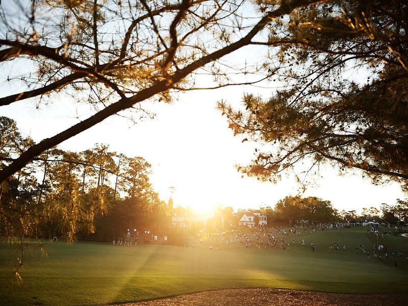  Patrons walks across the first hole during the first round.