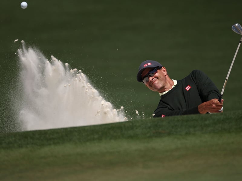 Adam Scott of Australia  plays a shot from a bunker on the second hole.