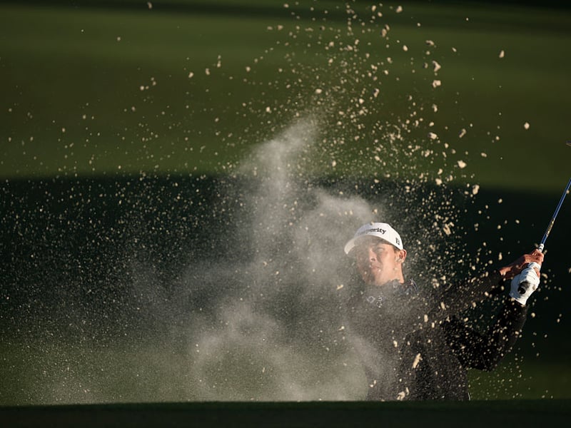 Johnny Keefer of the United States plays a shot from a bunker on the second hole.