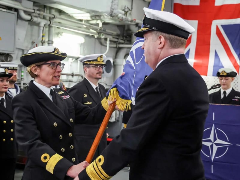 Pictured is Incoming Commander, Commodore Maryla Ingham RN, Standing NATO Maritime Group One Commander, takes hold of the NATO flag and command from Commander Allied Maritime Command, Vice Admiral Robert G Pedre CB RN at the Change of Command Ceremony, on board FGS Sachsen at HMNB Portsmouth
