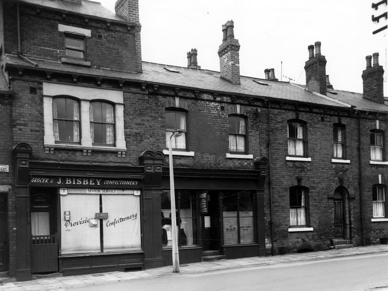 A grocers shop at 90 Joseph Street pictured in June 1964. To the right Winifred Hunt Bespoke Tailor has an office and fitting room at 88. The house on the right is 86. These were through properties with entrances from Ashbourne Place.