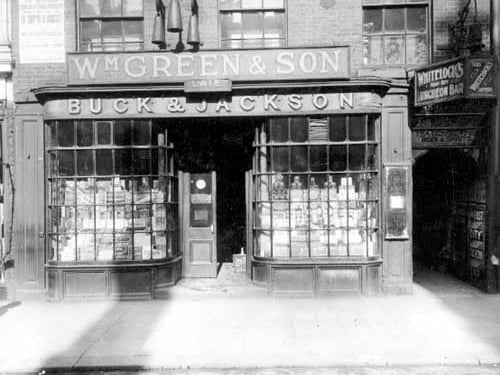 Premises of W.M. Green and Son grocers, formerly Buck and Jackson. A notice above shop gives details of sale of shop, William Green having died. To the right is the Turks Head Yard, with Whitelocks first City Luncheon Bar. Pictured in June 1922.
