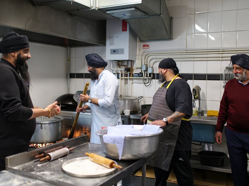 Volunteers making food for worshippers.
