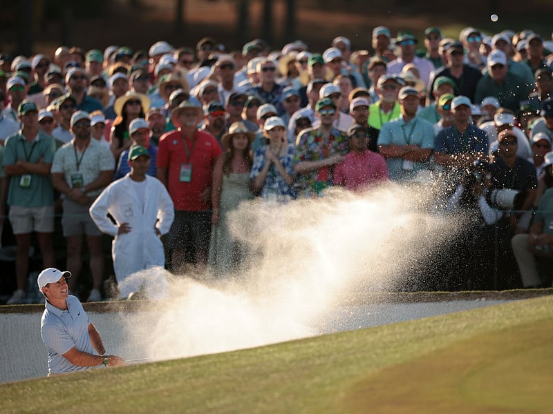 Rory McIlroy plays from the bunker on the 18th hole.