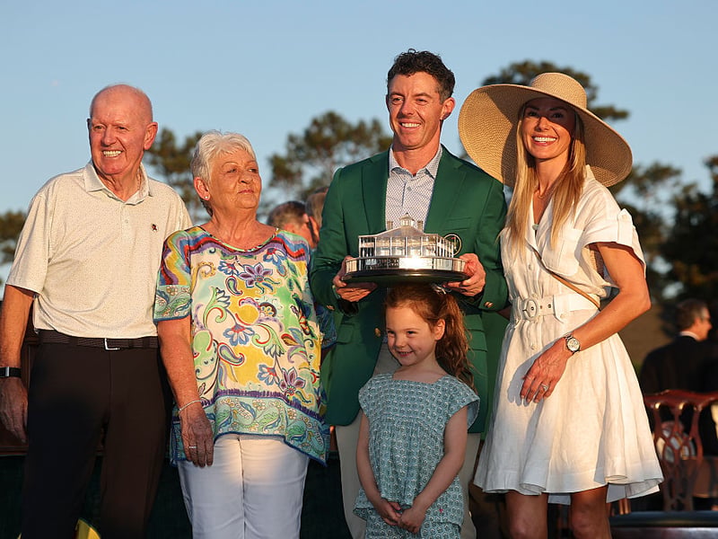 Rory McIlroy poses with the Masters trophy during the Green Jacket Ceremony alongside father Gerry, mother Rosie, wife Erica and daughter Poppy.
