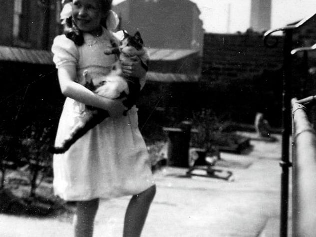The garden of number 18 Little Town Lane where a young girl is pictured with her cat. She is Judith Nussey, the granddaughter of Robert and Mary Harcourt who had lived in this house since 1904.